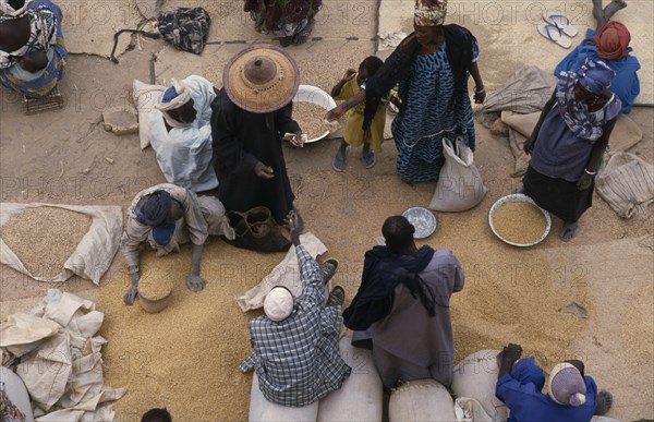 MALI, Sahel Desert, Tonka, Looking down on traders and customers making transaction at market stall selling grains and pulses.
