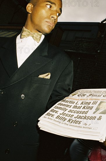 ENGLAND, London, Notting Hill, A man sells copies of The Final Call newspaper during the Notting Hill Carnival.