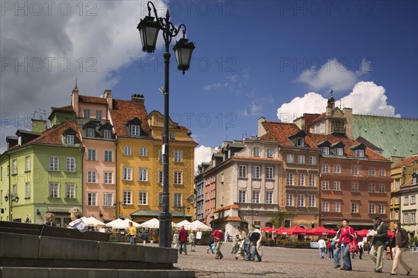 POLAND, Warsaw, "Plac Zamkowy, Castle Square in the Old Town. Outside seating, tables with parasols, lamppost and pedestrians."