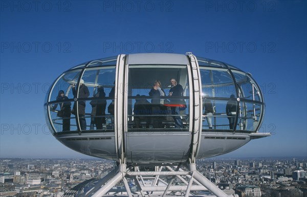 ENGLAND, London, British Airways London Eye capsule and the London skyline with tourist waving to camera from the pod.