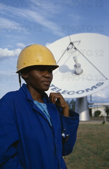 BOTSWANA, People, Work, Portrait of station supervisor of telecommunications company standing in front of satelite dish.
