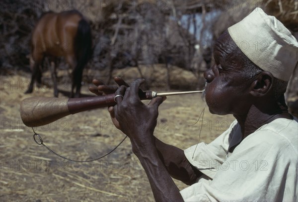 CHAD, Music, "Musician playing a shawm, a traditional double reed instrument"