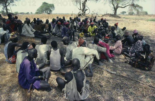 SUDAN, Tribal People, Guests at Dinka wedding listening to traditional story teller.