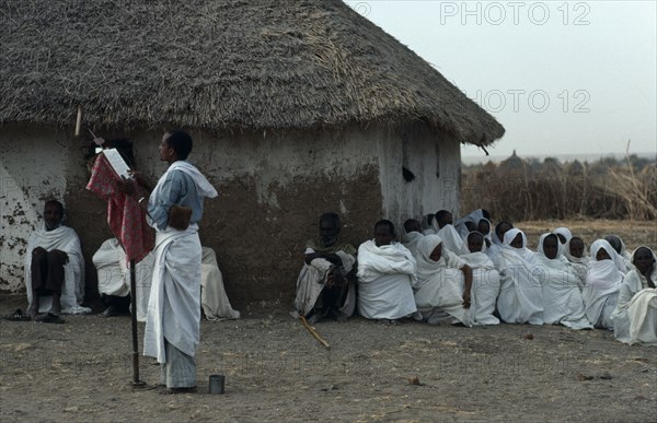 SUDAN, East, Religion, Coptic priest conducting open air othodox service in settlement for Ethiopian refugees.