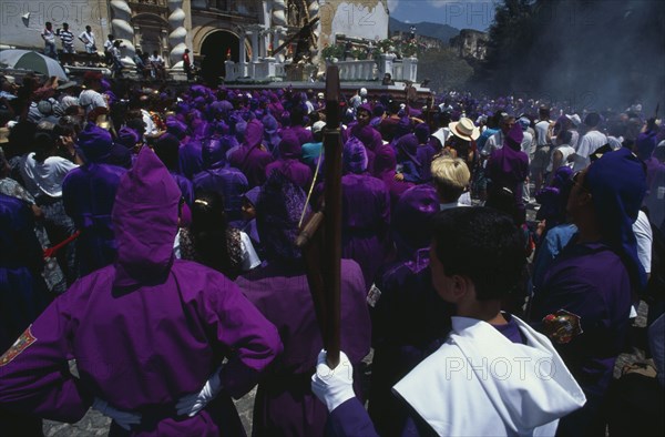 GUATEMALA, Antigua Guatemala, Easter Week procession with wooden float and figure of Christ carrying the cross raised above crowds.