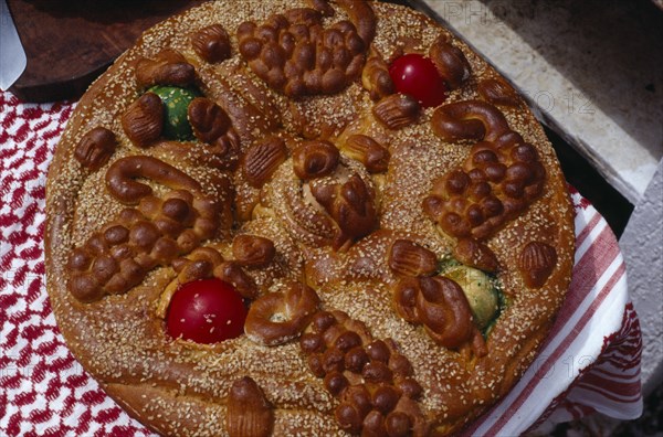 GREECE, Saronic Islands, Spetses, Easter bread decorated with painted hard boiled eggs and sesame seeds to be eaten on Easter Sunday.