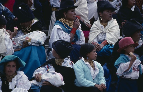 ECUADOR, Imbabura, Cotocachi, Spectators sitting on church steps to wait for Easter Sunday procession.