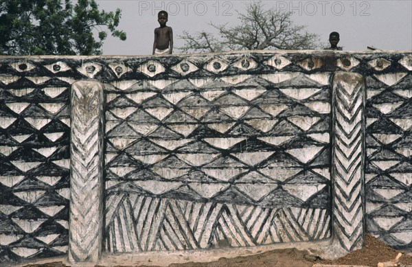 GHANA, Architecture, "Children on top of outside wall decorated with traditional broken calabash pattern in black and white, symbolic of ever useful. "