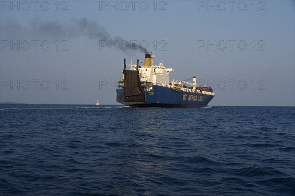 GHANA, Transport, Container ship leaving Tema port emitting stream of thick black smoke from central funnel.
