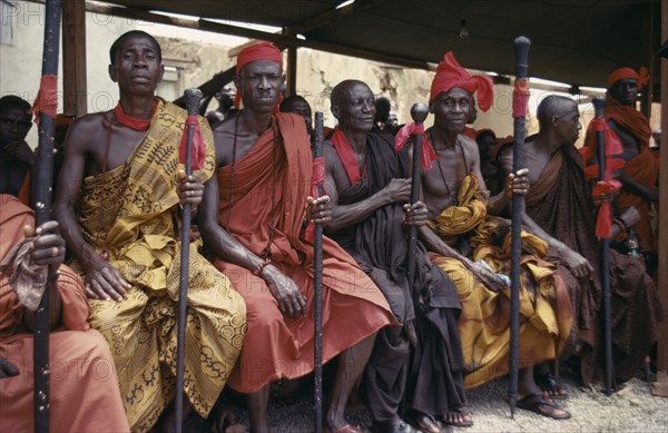 GHANA, Tribal People, Ashanti Akan tribal members holding staffs wrapped with red cloth attending funeral.  Red is the colour of mourning.