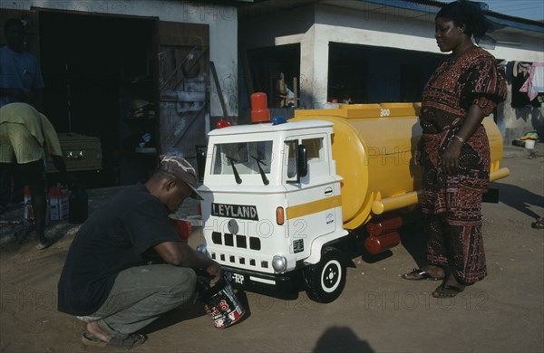 GHANA, South, Nungua, Craftsman painting oil tanker shaped coffin for driver Peter Borkety Kuwono following tradition of decorating coffin to reflect the life of the deceased.