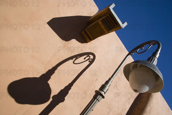 USA, New Mexico, Santa Fe, Street lamp and gutter detail with shadows on adobe style building