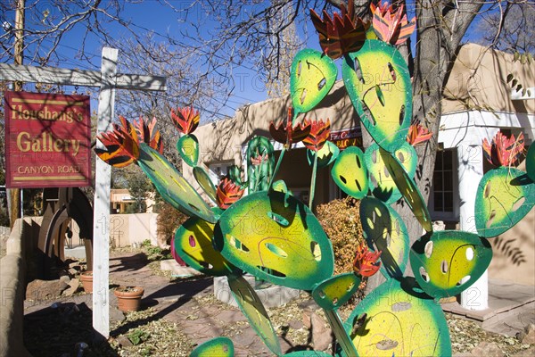 USA, New Mexico, Santa Fe, Houshangs art gallery on Canyon Road with a colourful metal sculpture of a cactus in the front garden