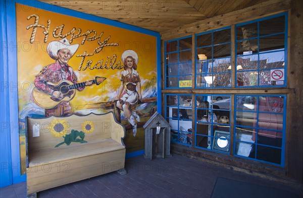USA, New Mexico, Santa Fe, Happy Trails local arts and crafts shop and its front wall painted with a picture of a cowgirl and a cowboy playing a guitar