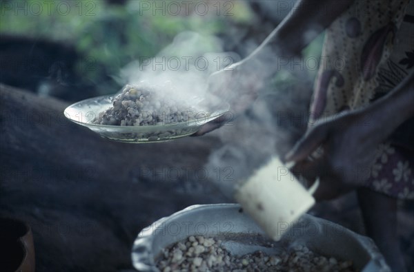 KENYA, Food, "Cropped view of woman holding plate of cooked beans, the staple diet of the Kambas, Bantu people who live in the semi-arid eastern province."