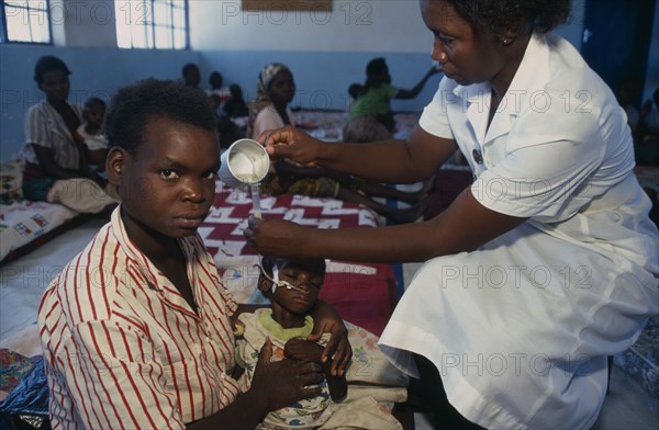 ZAMBIA, Mayukwayukwa Camp, Nurse feeding child through tube in day feeding centre for malnourished children in camp for Angolan refugees.