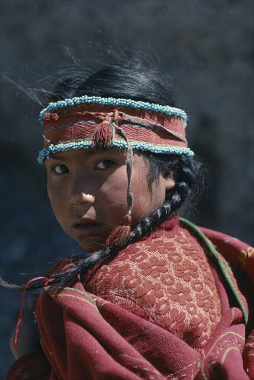 BOLIVIA, Tribal People, Portrait of young girl with hair in plaits and wearing woven head band decorated with turquoise beads.