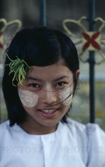 MYANMAR, Yangon, Portrait of young girl with sandlewood paste on her cheeks and nose used as a beauty enhancer.
