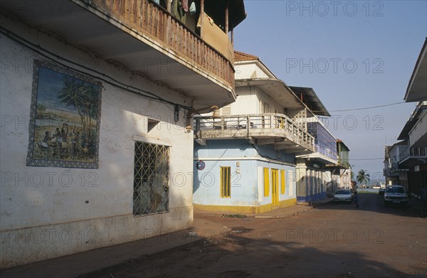 GUINEA BISSAU, Bissau, Quiet street in the commercial area with mural painted on exterior wall of building in foreground.