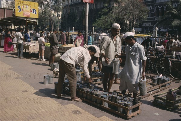 INDIA, Maharashtra, Bombay, Lunch time tiffin wallahs distributing tiffin boxes to city workers.