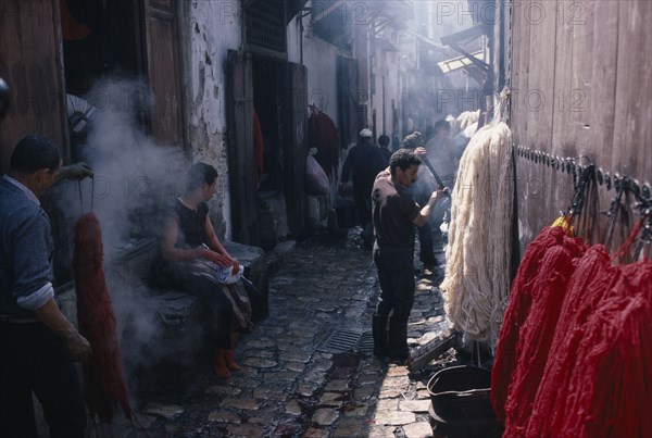 MOROCCO, Fez, Street scene in area of wool dyers with skeins of coloured wool hanging up to dry.