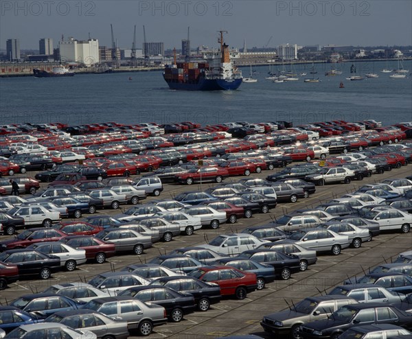 INDUSTRY, Cars, Southampton Docks. Rows of imported cars with container ships and boats on the water