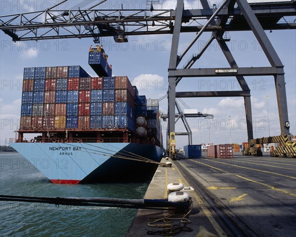 INDUSTRY, Shipping, Southampton Docks. Shipping Containers being moved from ship in dock with crane machinery