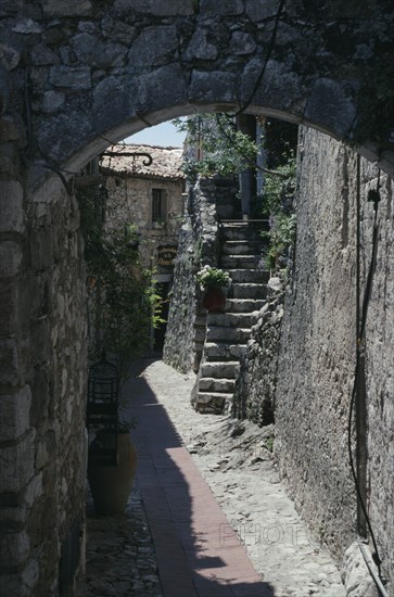 FRANCE, Provence Cote D Azur, Alpes Maritime, Eze. Walled alley way with stone steps leading up to building