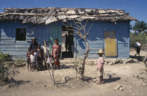 DOMINICAN REPUBLIC, Housing, Extended family outside brightly painted home.