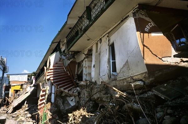 MEXICO, Chiapas, Tepachula, "October 2005, two weeks after the devastation of Hurricane Stan and most of Chiapas and the Pacific side of Guatemala are still 'incommunicado' and desperately in shock. As locals begin to re-piece their shattered lives, I start to hear vivid accounts and see the aftermath of Stan's incredible destruction that was unfortunately less than adequately covered by the majority of media outlets. After seeing the impact of the previous Hurricane Katrina in the US, the accounts of Stan's destruction in Chiapas and Guatemala, were yet another reminder, of the inequitable severity of destruction these natural disasters have on poor and marginalized sectors of an affected population. The destruction is a couple of miles outside the centre of town and shows crumpled buildings, twisted staircases, broken pipes and cables, heaps of rubble and debri. The focus of the photo is a destroyed hotel, where one can just about make out the reception sign amongst the destruction. ...