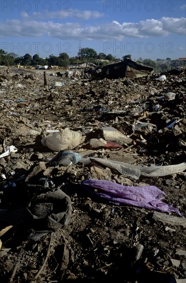 NICARAGUA, Managua Province, Managua, "The 'waste basket of Chureca' has existed since the late 1960's in the Acahualinca district of Managua, Nicaragua. It covers 42 hectares, is bombarded with thousands of tonnes of waste a day and is home to over 170 struggling families. By day over 1500 more Nicaraguans arrive at the site, some of whom are children who have been sent by their parents, others come by their own initiative. All compete with the adults to find, harvest and re-sell recyclable material. Of the minors who go to the waste basket - 88% it has respiratory problems, 62% suffer from parasites and 42% have serious skin diseases. Although the sky is clear and blue the air is thick of burning waste or rotting waste. Little houses or 'casitas' lie in a mixed muddle of rubbish and waste. The houses at the back of shot are made up of an eclectic collection of doors, wooden planks, dustbin bags, hanging bits of ripped tarpaulin, corrugated iron strips and whatever waste material seem...