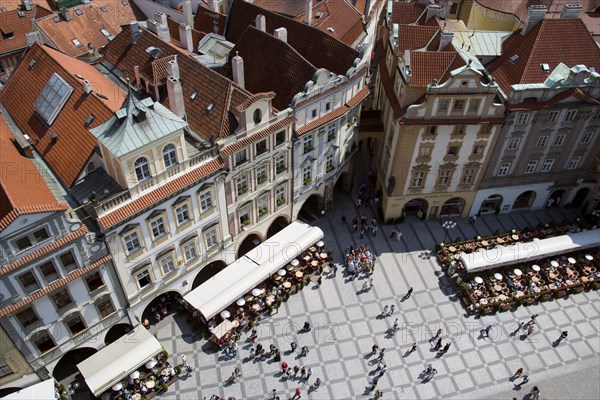 CZECH REPUBLIC, Bohemia, Prague, Restaurant and cafe tables with strolling pedestrians in the Old Town Square