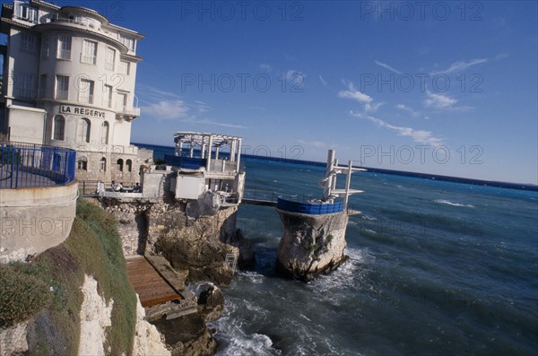 FRANCE, Provence Cote d’Azur, Alpes Maritimes, Nice. Cap de Nice. Diving port built on rocks along coastline next to La Reserve building