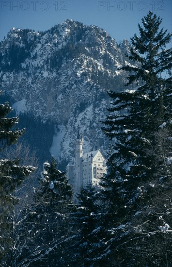 GERMANY, Bayern, Schloss Neuschwanstein, Castle built on rock ledge over the Pollat Gorge near Fussen in the Bavarian Alps in snowy mountain and pine forest landscape.