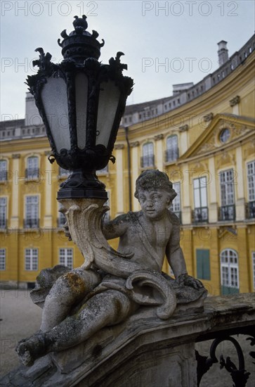 HUNGARY, Fertöd, Eszterhazy Palace, Detail of carved stone balustrade and lamp with part view of curved exterior of palace behind.