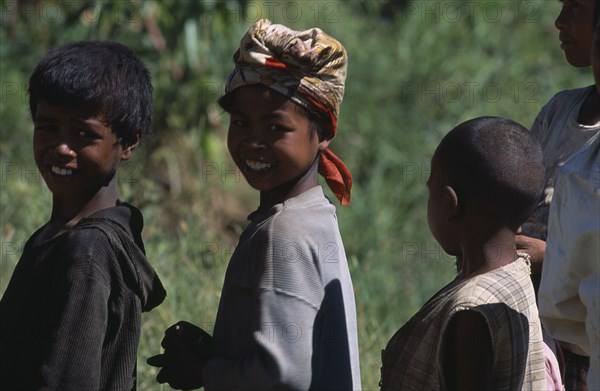 MADAGASCAR, People, Children , Portrait of a girl wearing a headscarf standing amongst two other children