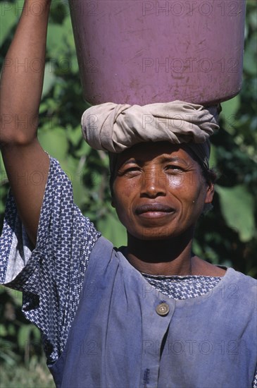 MADAGASCAR, People, Women, Portrait of a woman carrying a water bucket on her head