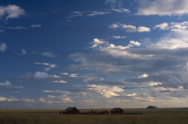 MADAGASCAR, Landscape, Small settlement in the Horombe Plateau with an expanse of sky and cloud formations above