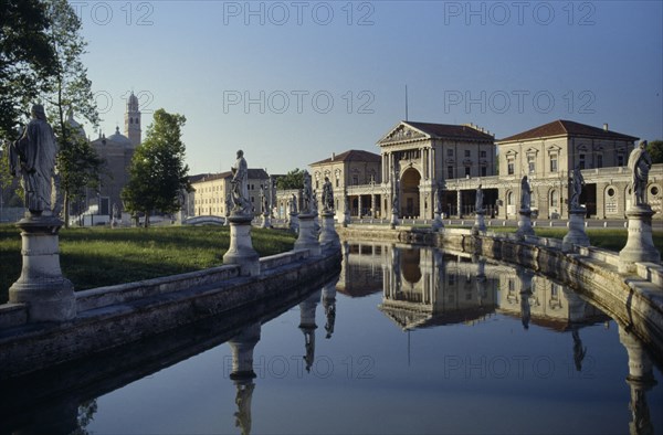 ITALY, Veneto, Padua, Prato della Valle.  Canal surrounding oval green island along which stand statues of famous cultural figures.