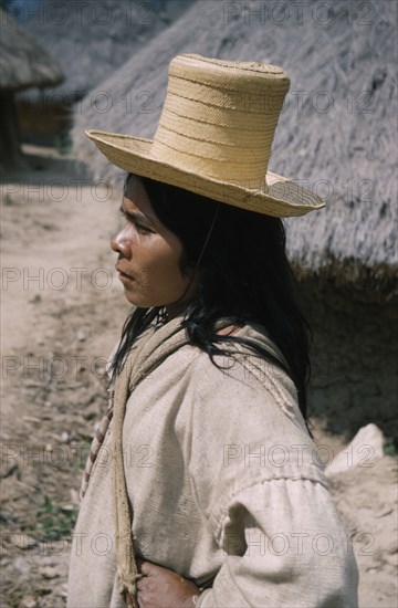 COLOMBIA, Sierra Nevada de Santa Marta, Kogi Tribe, "Portrait of young Kogi vasayo / commoner with straw hat, woven cotton “manta” / cloak and woven “fique” (cactus fibre) shoulder bags"