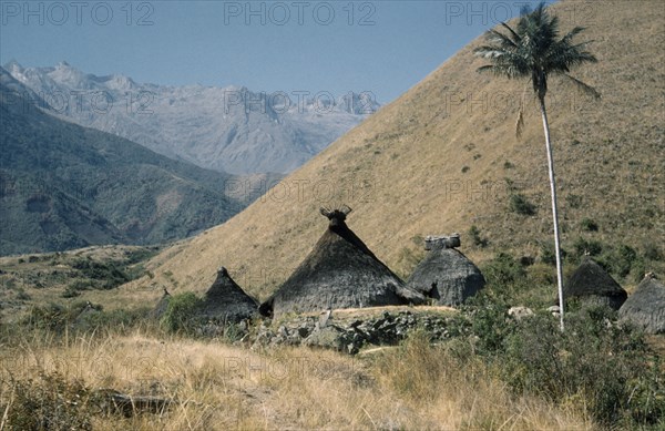 COLOMBIA, Sierra Nevada de Santa Marta, Kogi Tribe, Religious centre of Takina where very young boys are trained to become “mamas” / priests. Racks of sacred potsherds at apex of each “nuhue” / temple roof. Lesser peaks of Sierra Nevada in background