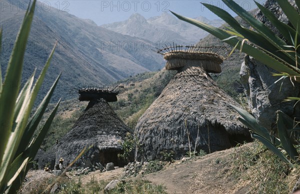 COLOMBIA, Sierra Nevada de Santa Marta, Kogi Tribe, Religious centre of Mamarongo; well preserved racks of potsherds at roof apices. Granite seats for “mamas”  / priests outside second nuhue / temple
