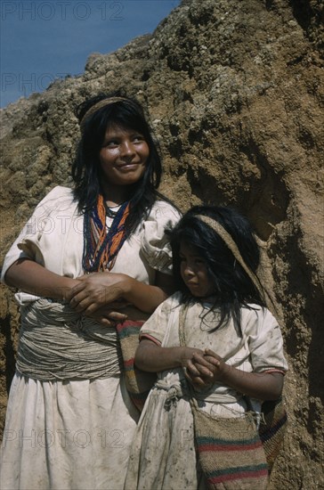 COLOMBIA, Sierra Nevada de Santa Marta, Ika Tribe, "Portrait of two sisters, both wearing typical woven cotton garments.  Elder sister with many stranded waist belt and necklace of coloured glass beads, a sign of wealth. Younger sister with “fique” / cactus fibre “mochila” / shoulder bag."