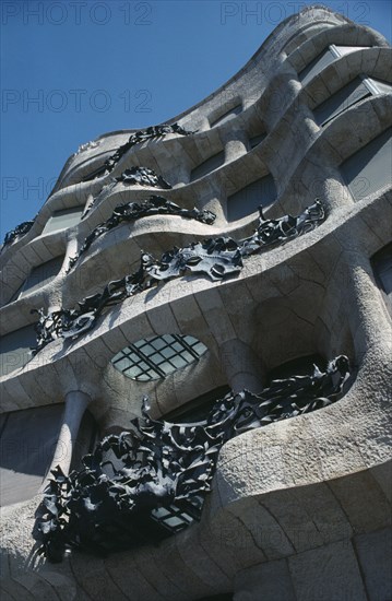 SPAIN, Catalonia, Barcelona, "Casa Mila or La Pedrera by Antonio Gaudi, built 1906-1910.  Detail of exterior facade showing wave like stone walls and ironwork balconies."