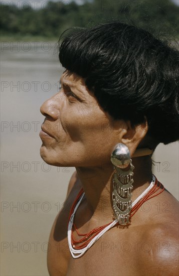 COLOMBIA, Choco Region, Noanama Tribe, "Headman with ornate silver earplugs, coloured glass bead necklace (beads are valuable trade goods) and typical Noanama pudding-basin haircut"