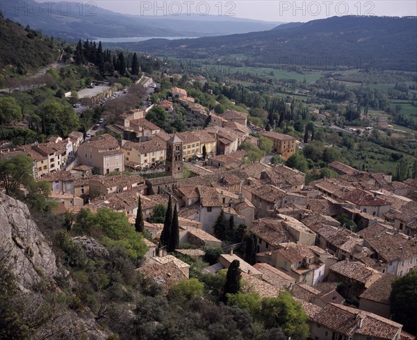 FRANCE, Provence Cote d’Azur, Alpes Haute de Provence, View South over the roof tops of the village Moustiers Saint Marie with the Saint Croix lake in the background