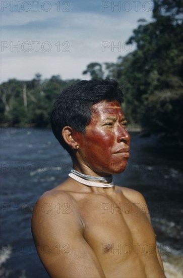 COLOMBIA, Vaupes Region, Tukano Tribe, "Portrait of Marco, a hunter with red “karajuru” facial paint, wooden ear-plug and strings of precious white and pale blue glass beads (traded throughout Amazonia)"