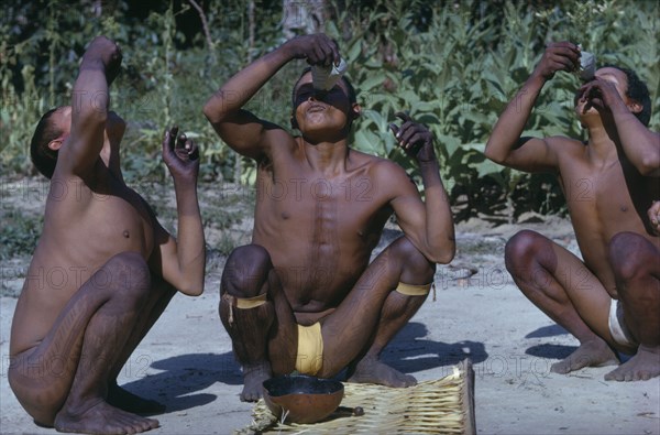 COLOMBIA, Vaupes Region, Tukano Tribe, Men pour very hot aji / red pepper juice down nostrils to cure their hangovers after the festival