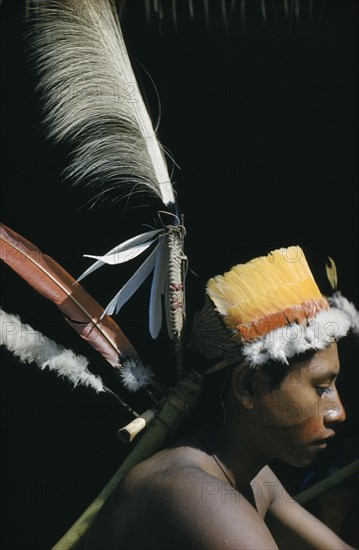 COLOMBIA, Vaupes Region, Tukano Tribe, "Portrait of Uriel, young man with fine feather head-dress of royal crane, macaw, toucan and egret feathers. Note feathers are woven into the head-dress with “cumare” fibre and attached to a banana stem and a deerbone."