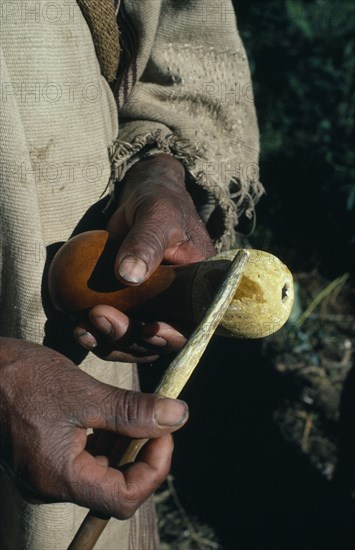 COLOMBIA, Sierra Nevada de Santa Marta, Kogi Tribe, Detail of a Kogi man holding his poporo/gourd of fine lime powder made from burnt seashells collected along Caribbean coast. The palito/stick transfers lime powder from gourd to mouth and wad of coca leaves held in cheek. Lime acts as catalyst releasing very small amount of cocaine alkaloid from coca leaves  this has effect of deadening pangs of hunger  keeping person awake and giving sense of wellbeing